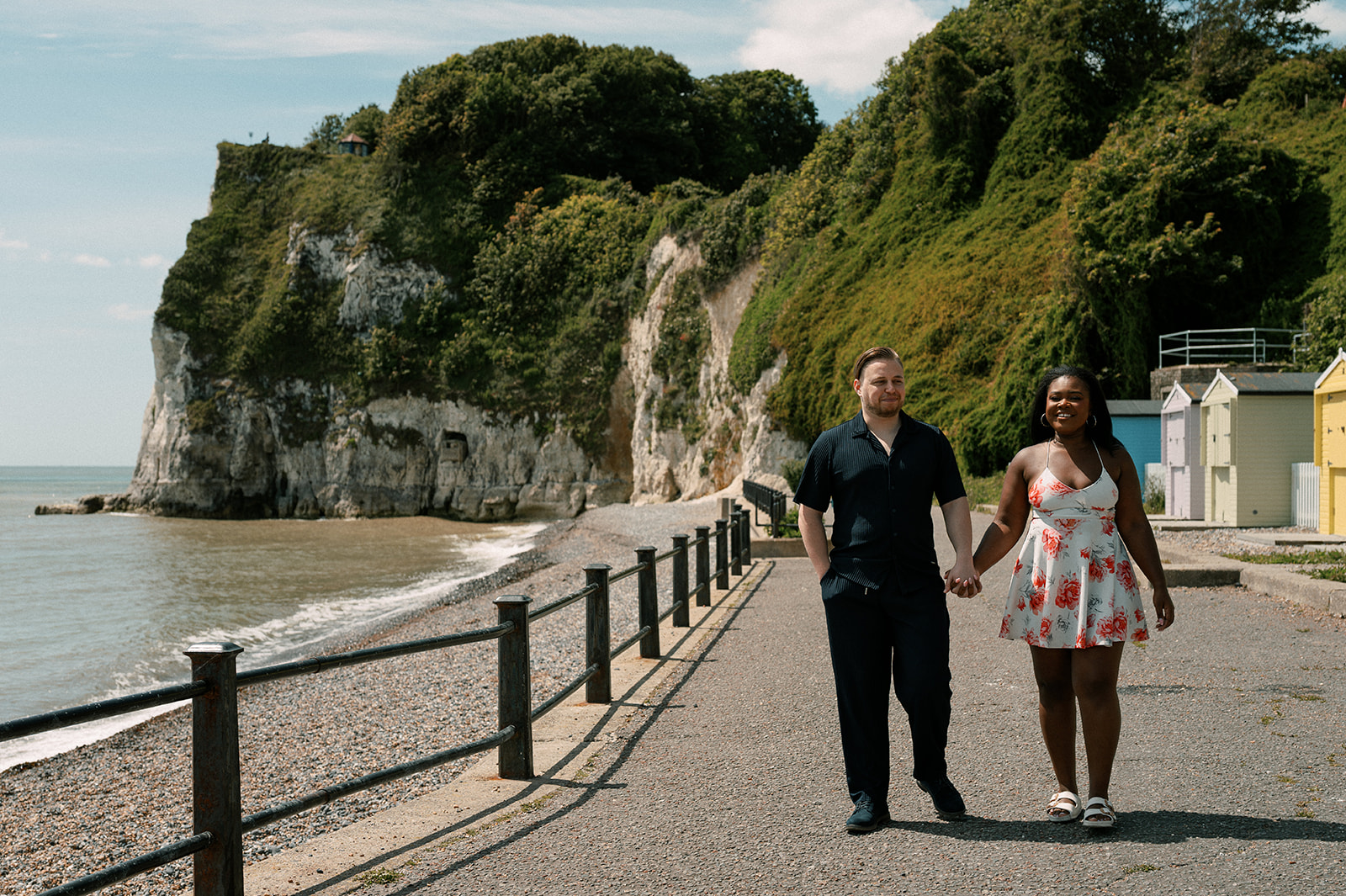 Walking hand in hand by the cliffs and beach huts